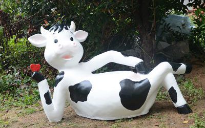 公園創(chuàng)意一只臥著玻璃鋼卡通奶牛雕塑