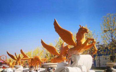 城市街道路邊擺放的一排玻璃鋼漆金飛馬雕塑